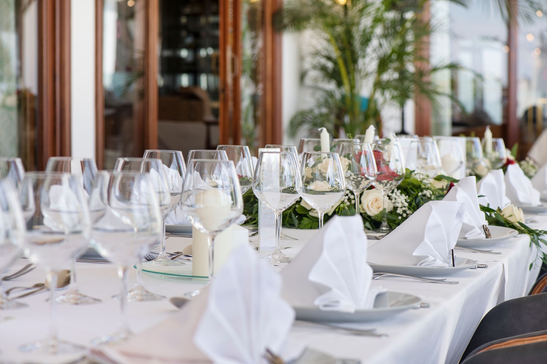 Tischdekoration für einen besonderen Anlass wie eine Hochzeit oder eine Feier mit perfekt aufgereihtem Besteck und Geschirr
